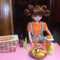 Adorable doll is making orange juice.